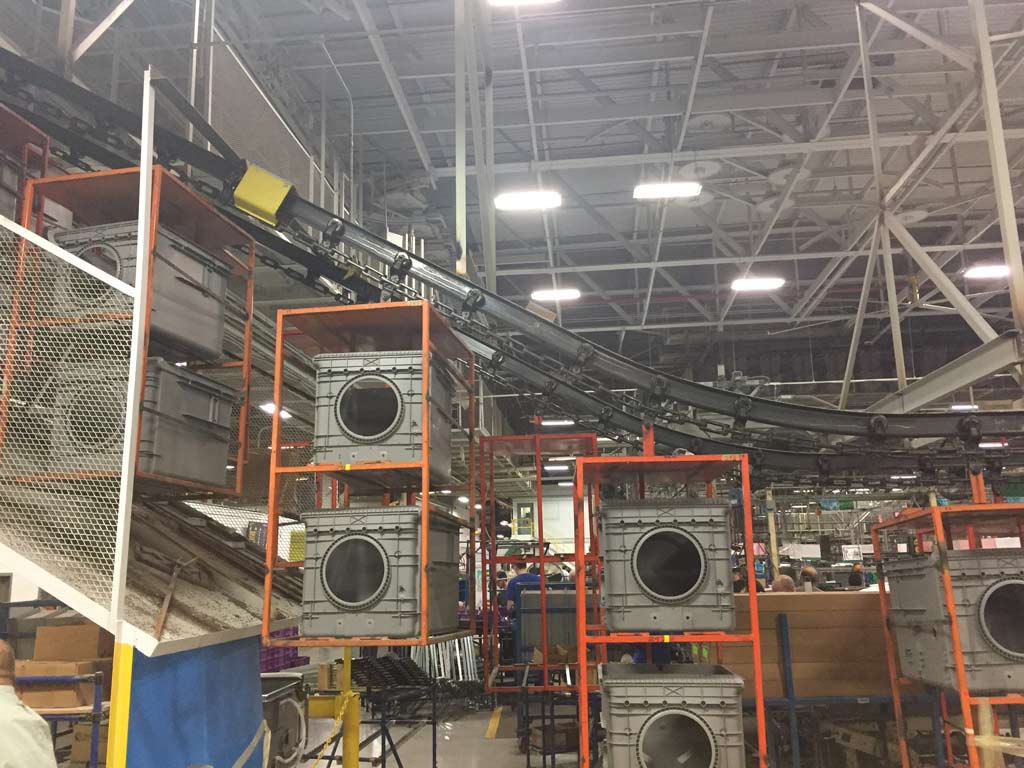 overhead conveyor belt carrying large metal boxes